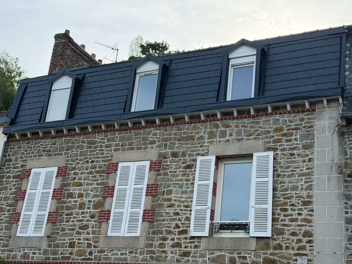 Façade en pierre surmontée de trois lucarnes habillées en aluminium